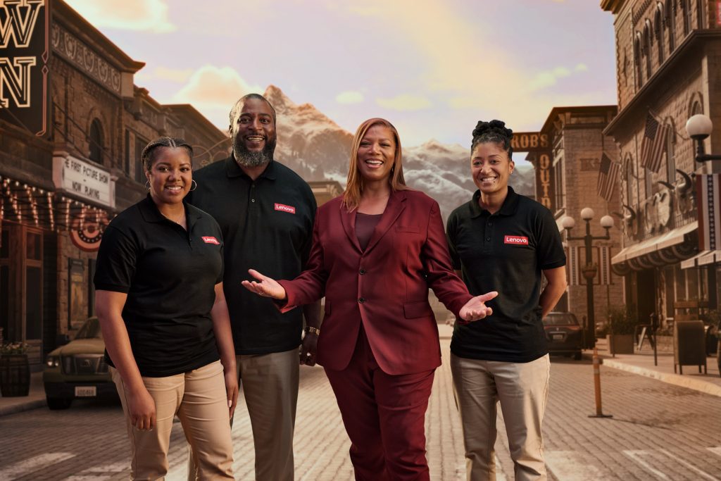 Queen Latifah with the Lenovo Evolve Small team standing on a small-town main street with a mountain in the distance.