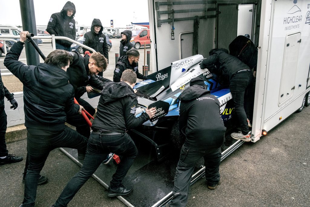 UWR team loading a race car into a trailer.