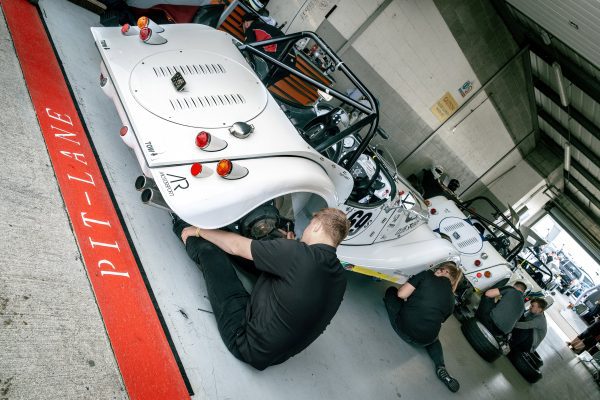 UWR teams working on a car in a garage.