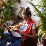 Brand image - Person using a Lenovo laptop in their home, surrounded by plants.