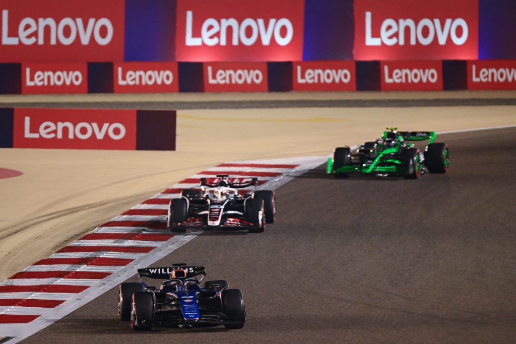F1 cars on the track with Lenovo logos in the background