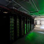 dark datacentre with green lighting and server racks