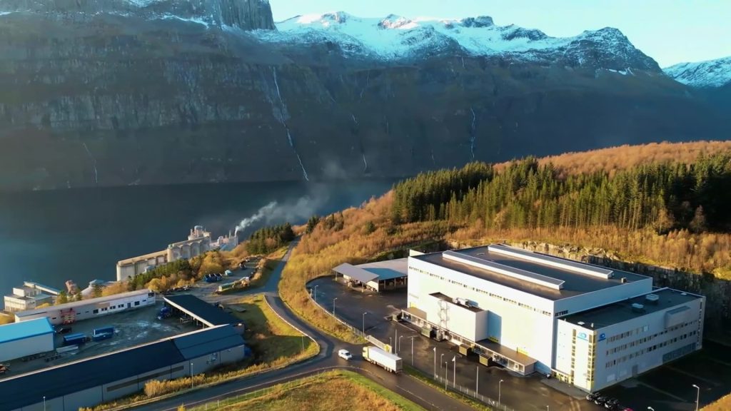 Wide shot of facility and mountains.