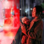 Brand image - Woman holding baby while window shopping